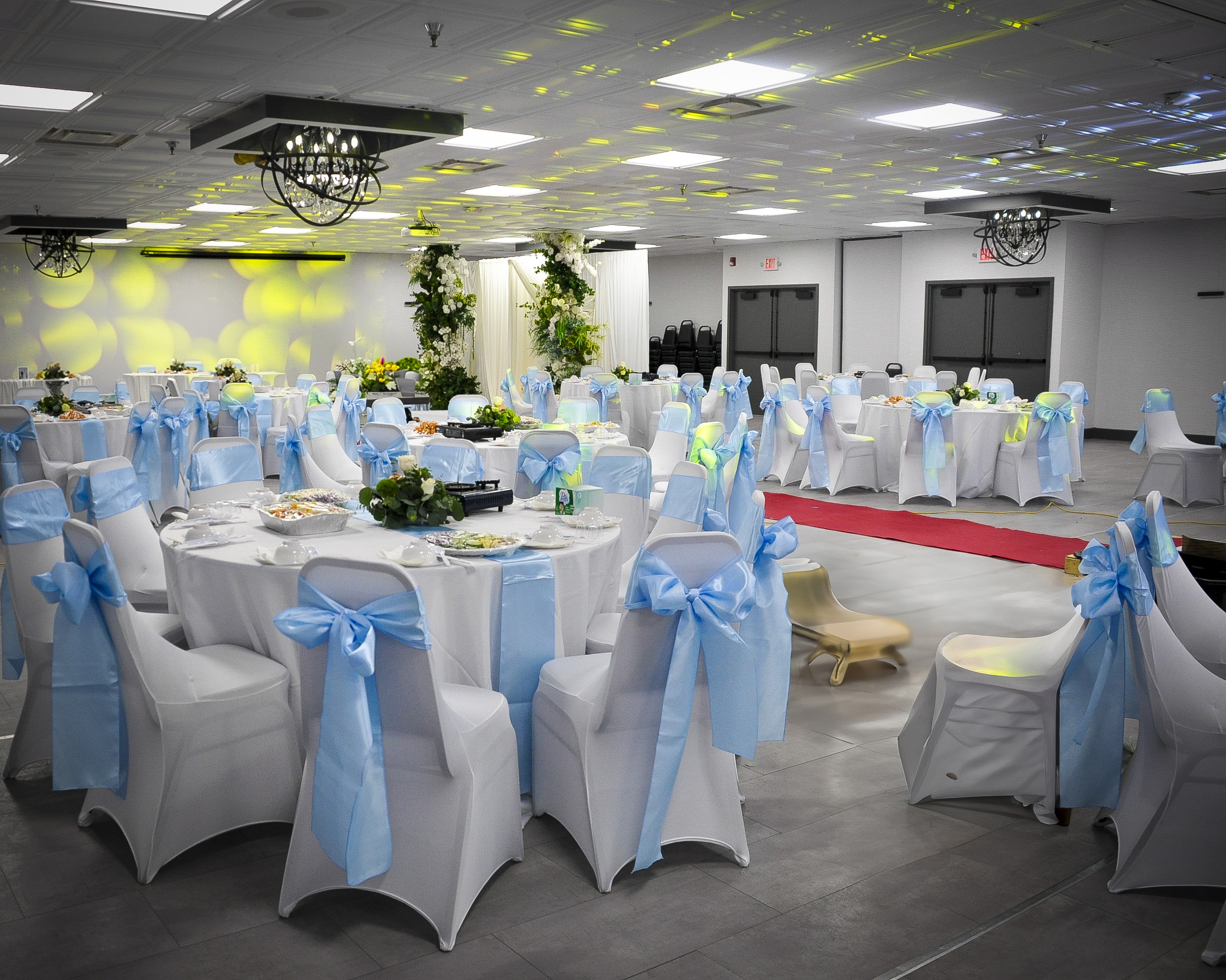 Wedding reception with pale blue chair bows and red aisle runner