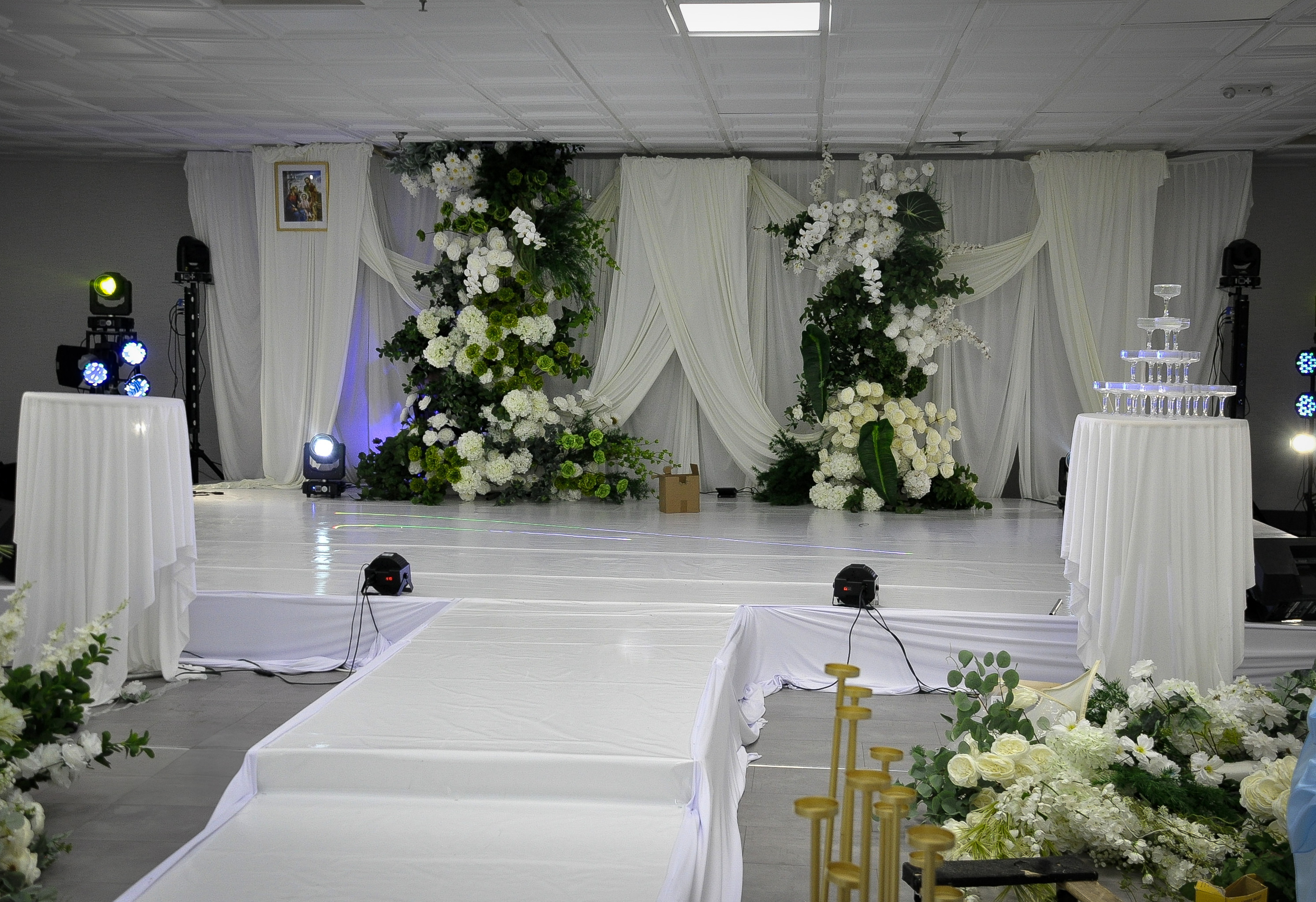 Wedding stage framed by florals and candle pedestals